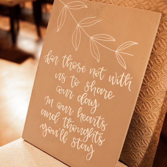 Grey wooden sign, lettered with an in loving memory quote