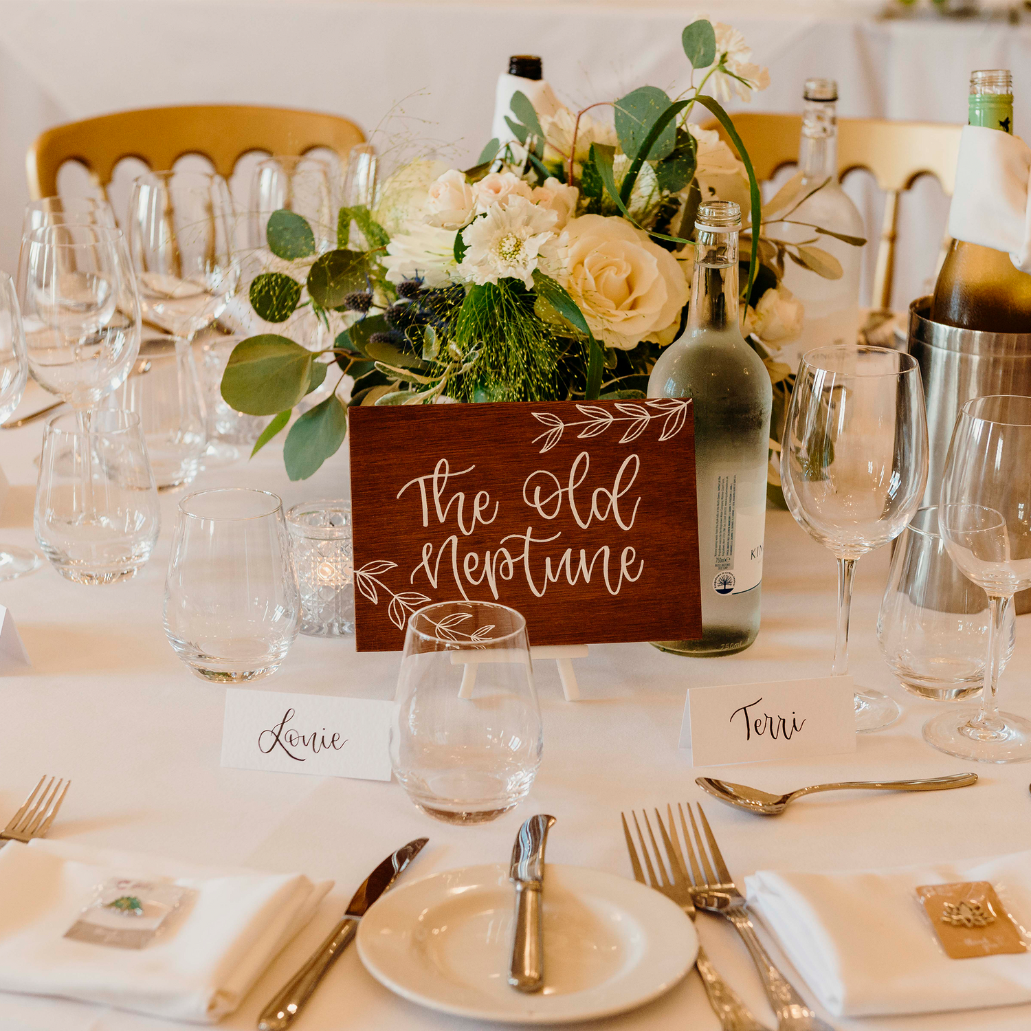 Wedding table setting with brown table number, hand lettered onto wood